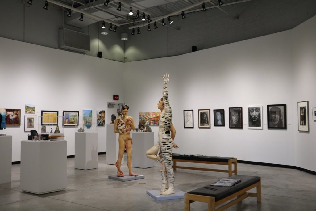 Models in animal costumes pose in an art gallery