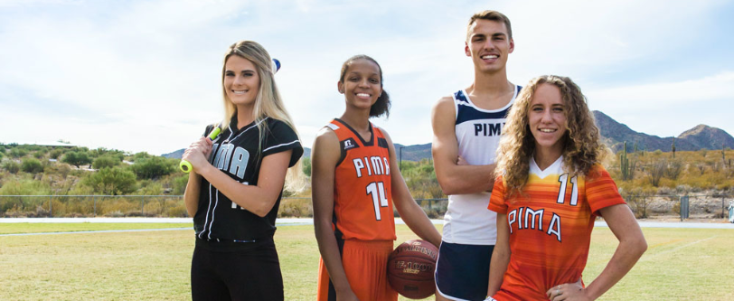 PCC athletes stand together in their orange and blue uniforms
